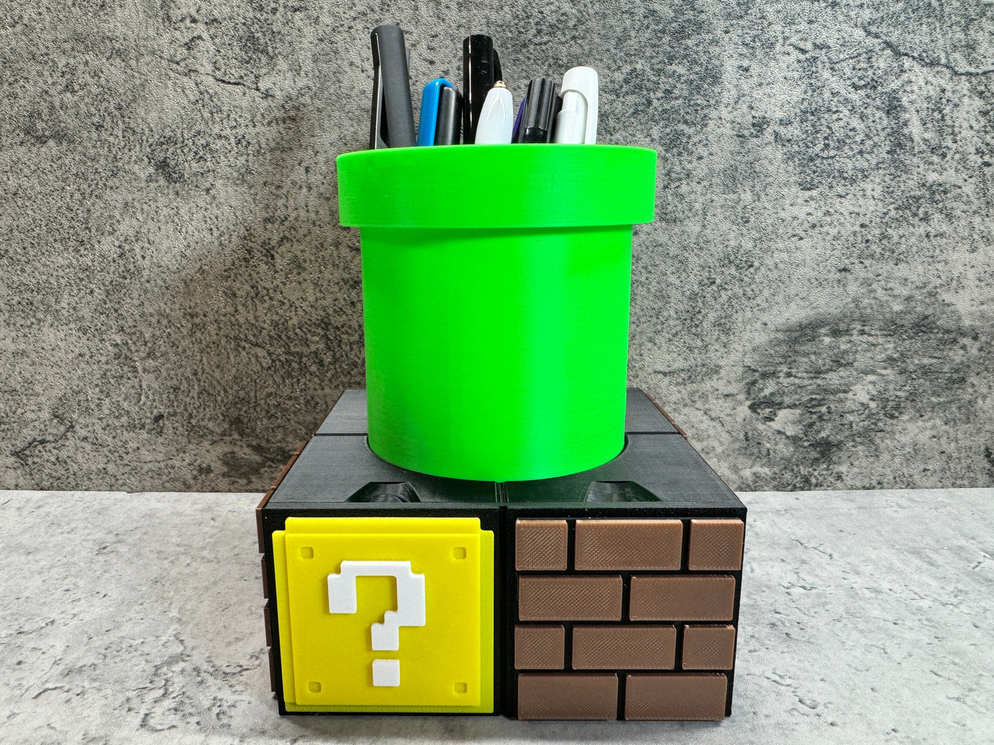 a green cup sitting on top of a block with a question mark on it