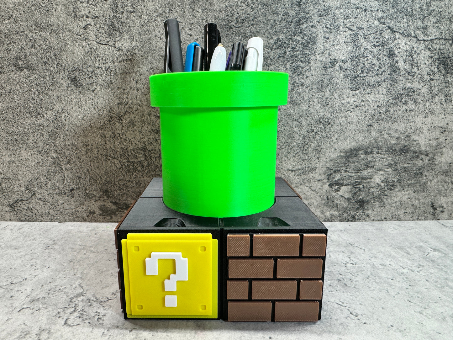 a green cup sitting on top of a block with a question mark on it