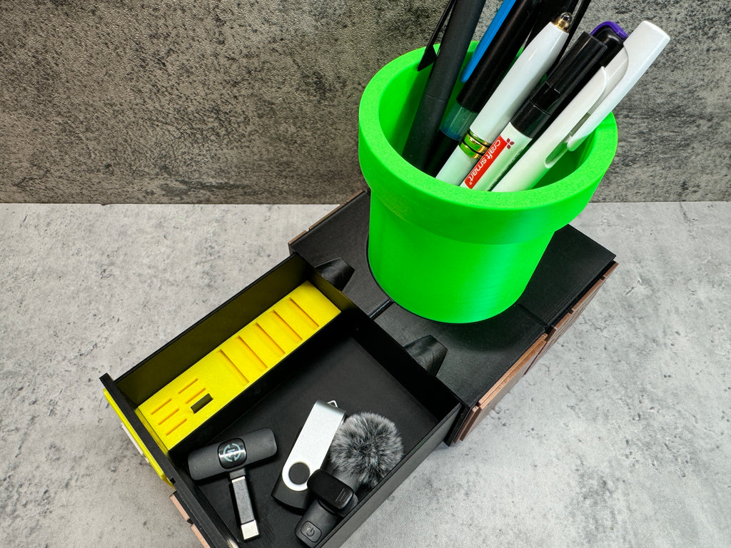 a green cup filled with pens and other office supplies