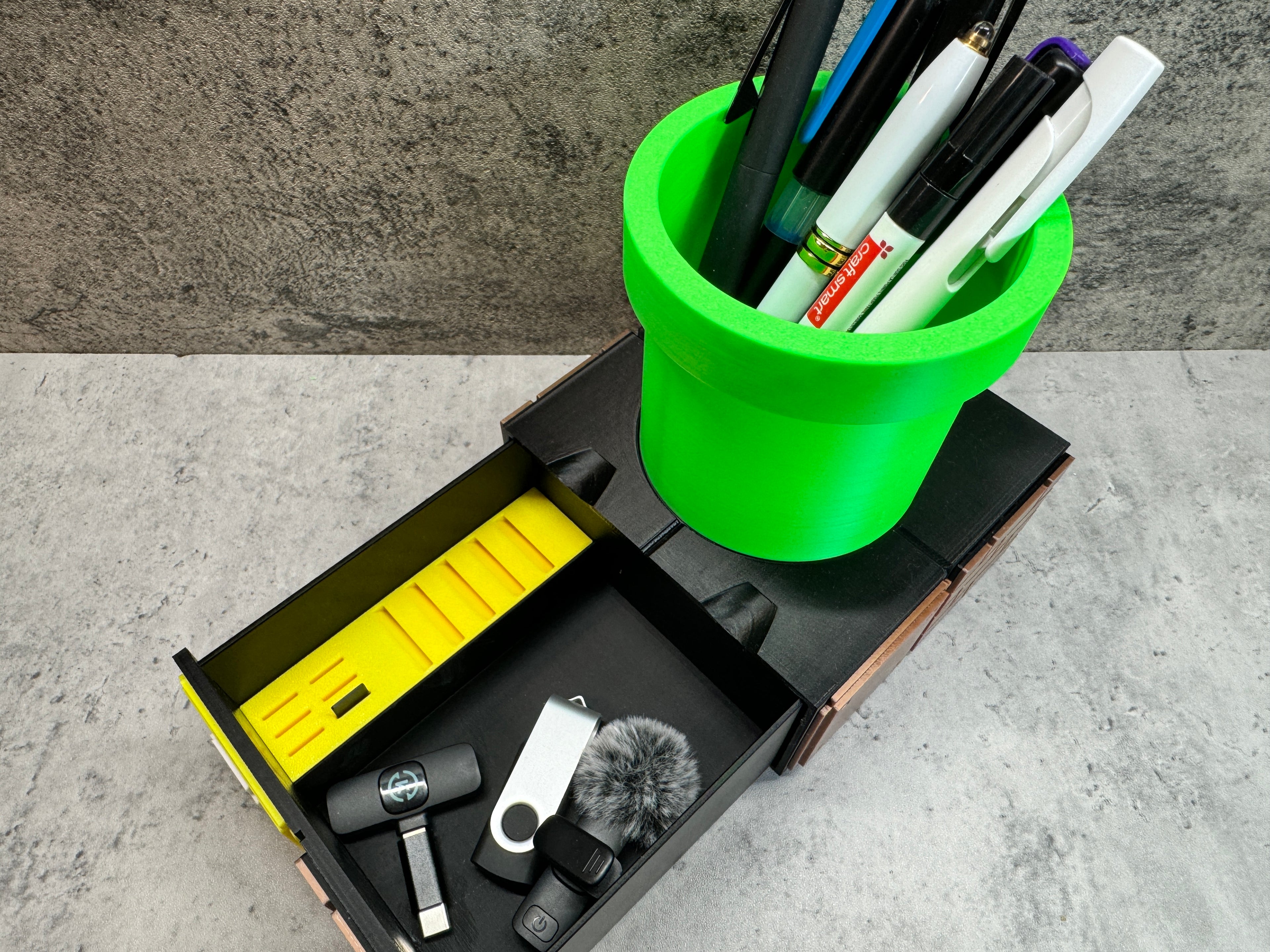a green cup filled with pens and other office supplies