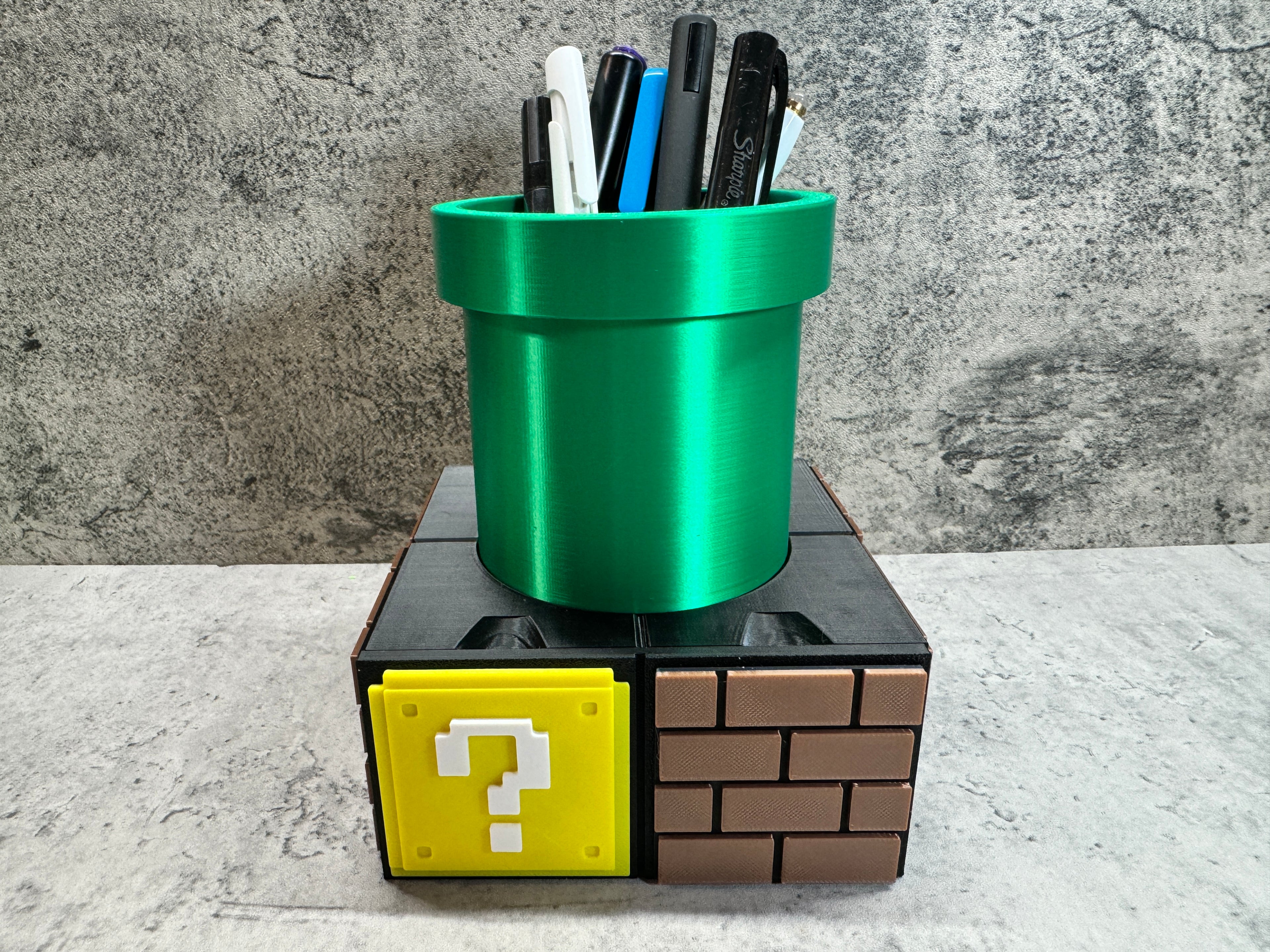 a green cup with pens and markers in it