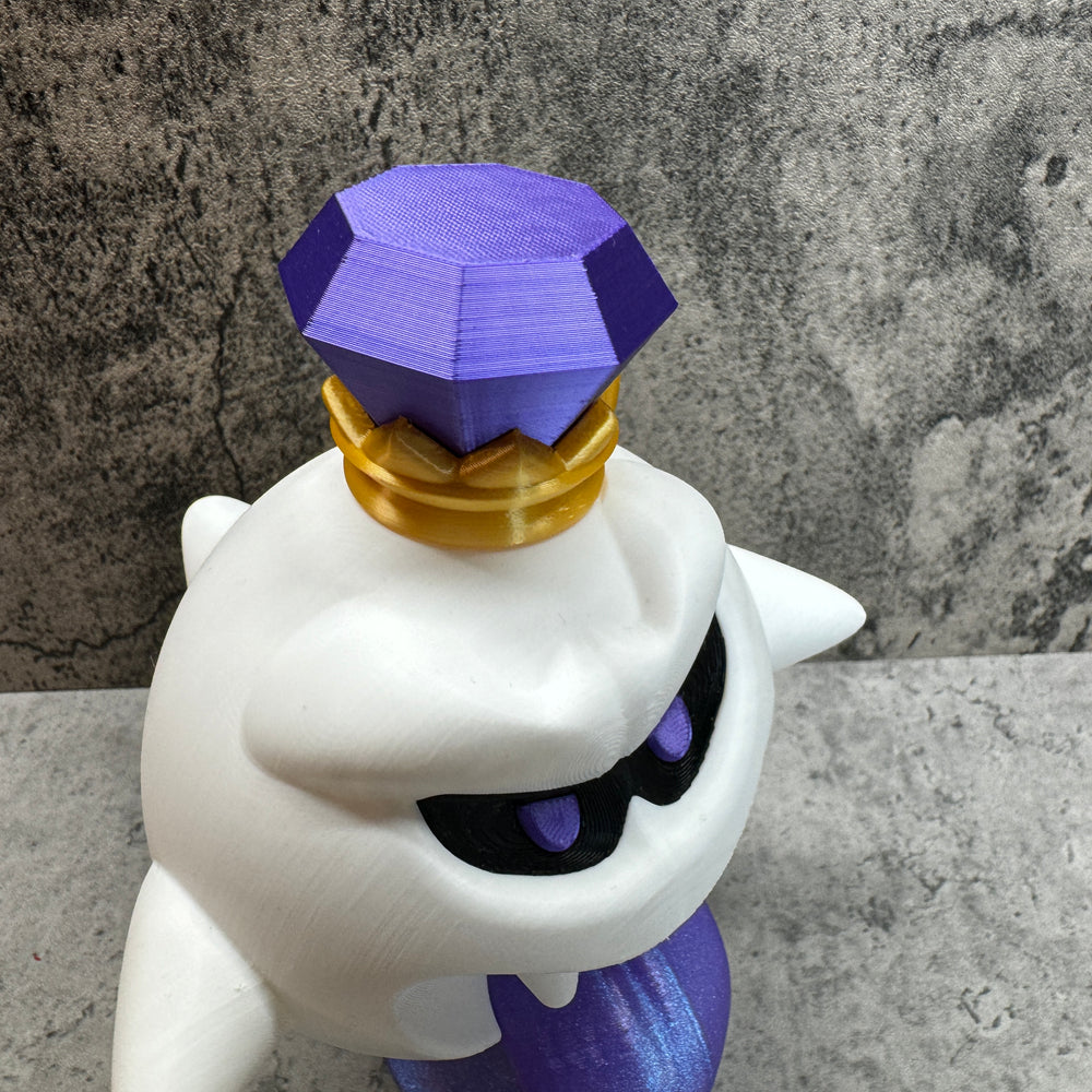 
                  
                    a purple and white cat figurine sitting on top of a table
                  
                