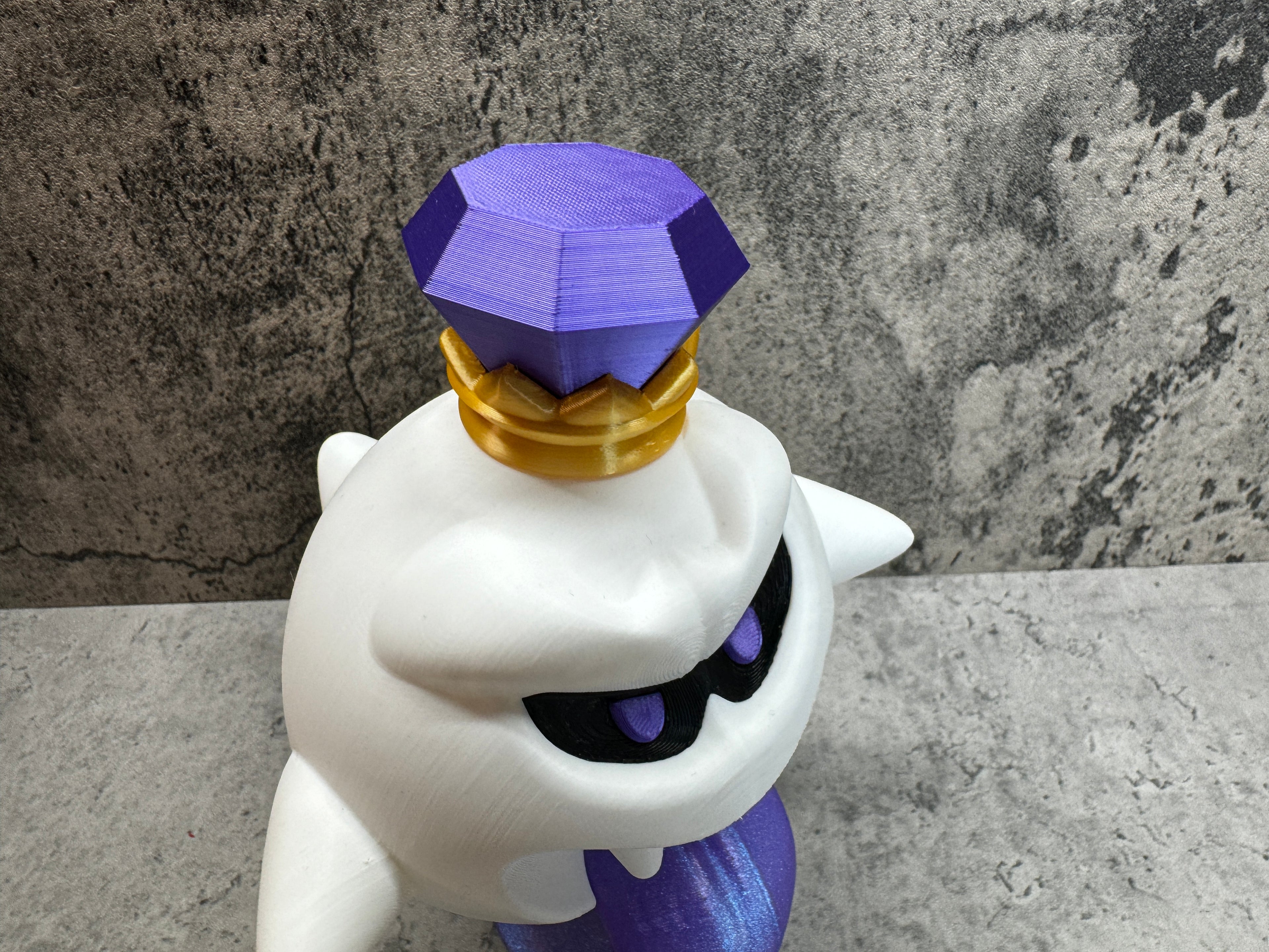 a purple and white cat figurine sitting on top of a table