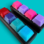 Colorful keycaps on a black keyboard tray against a teal background