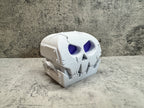 a white skull with blue eyes on a table