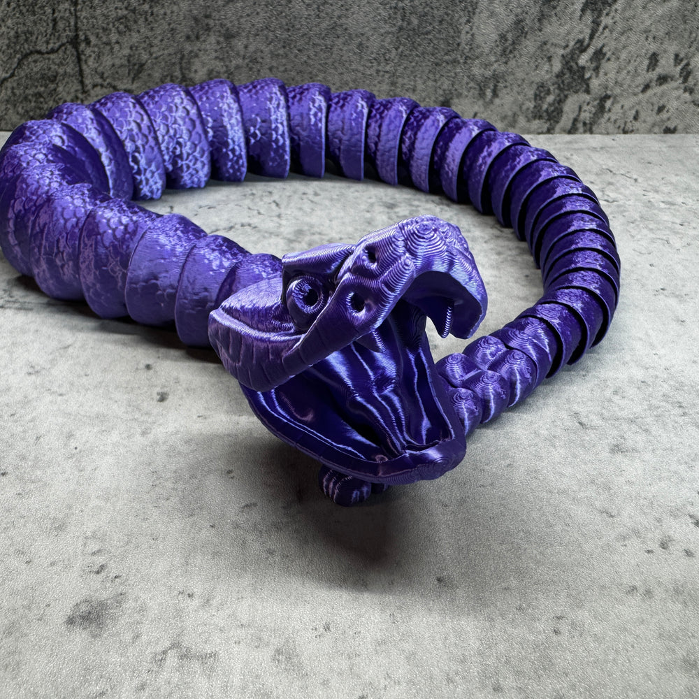 
                  
                    a purple snake sculpture sitting on top of a table
                  
                