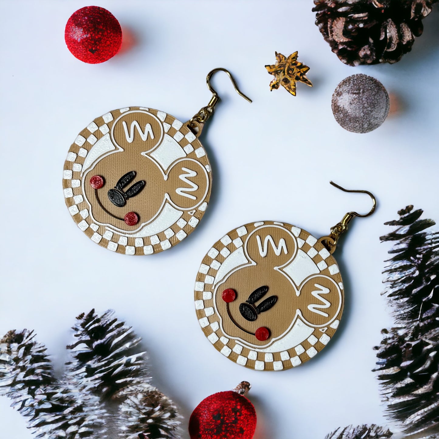 a pair of christmas themed earrings on a white surface