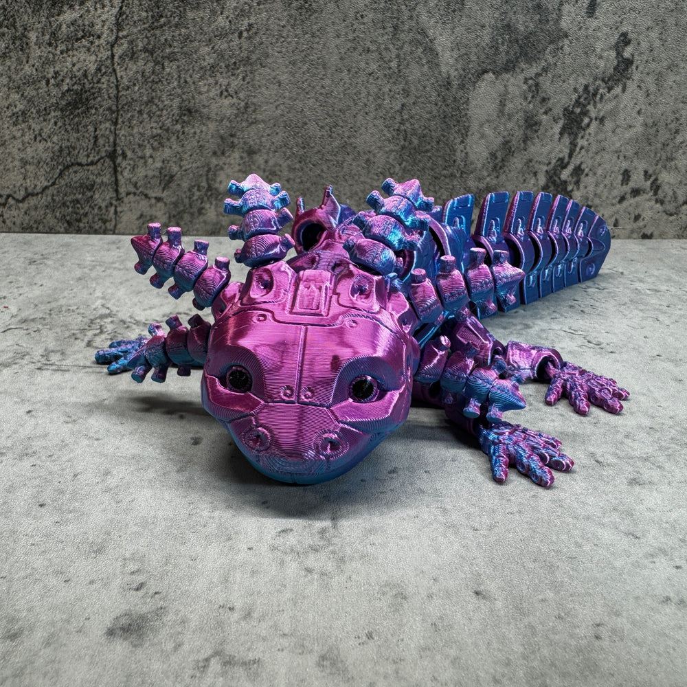 
                  
                    a purple and blue toy lizard sitting on top of a table
                  
                