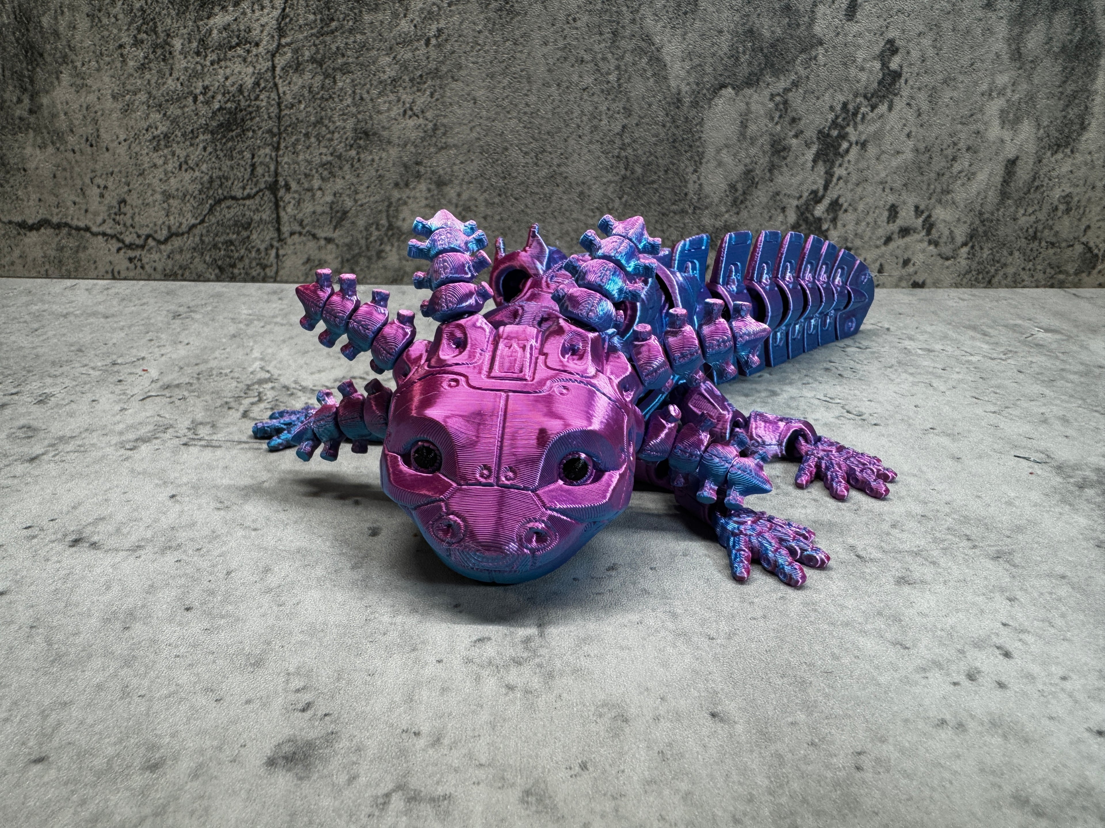 a purple and blue toy lizard sitting on top of a table