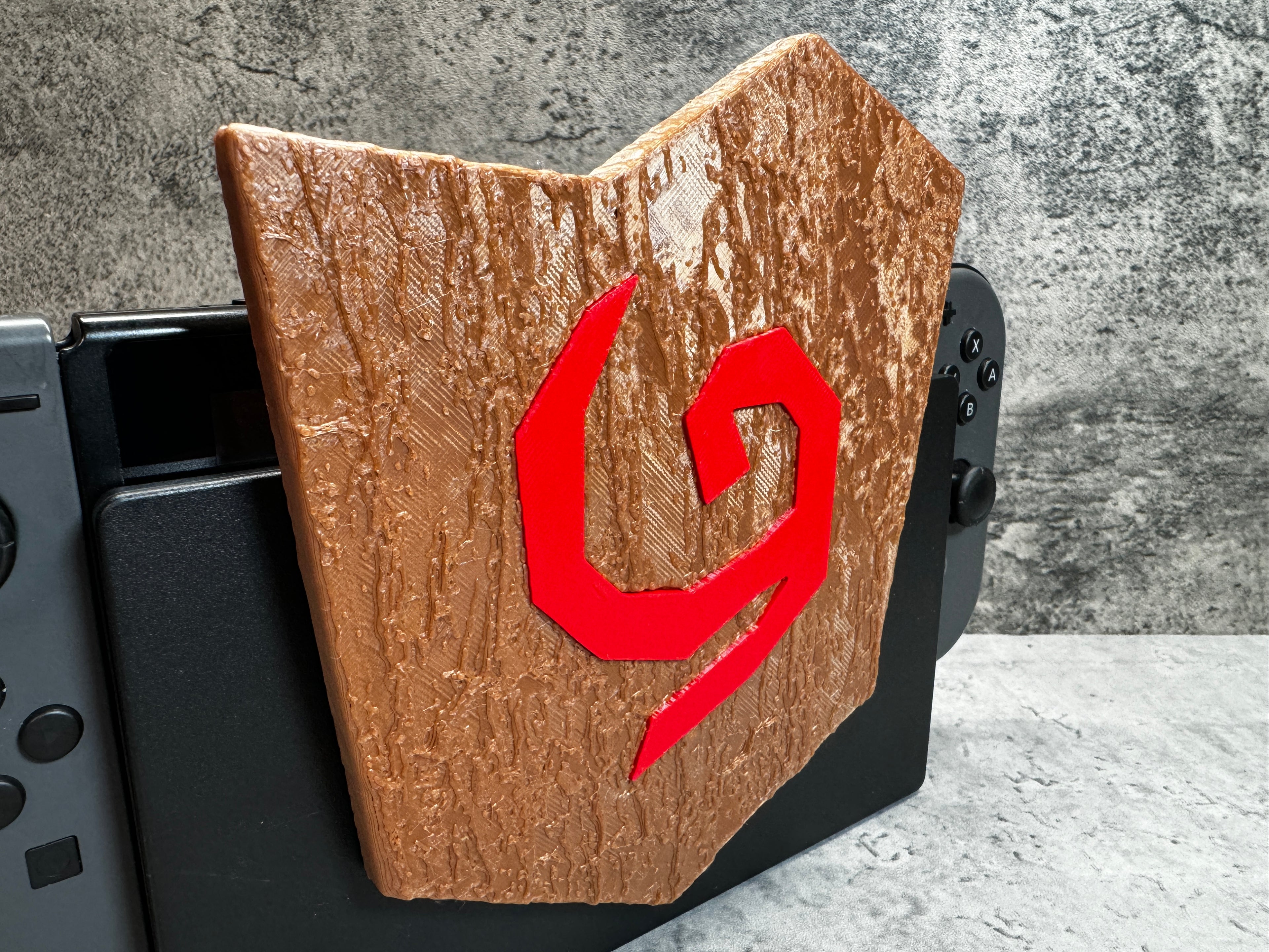 a close up of a wooden object with a red letter on it