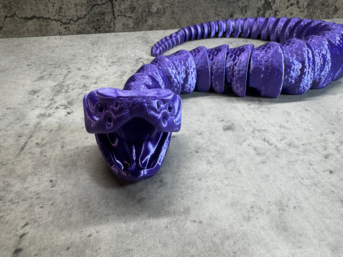 a purple object sitting on top of a cement floor