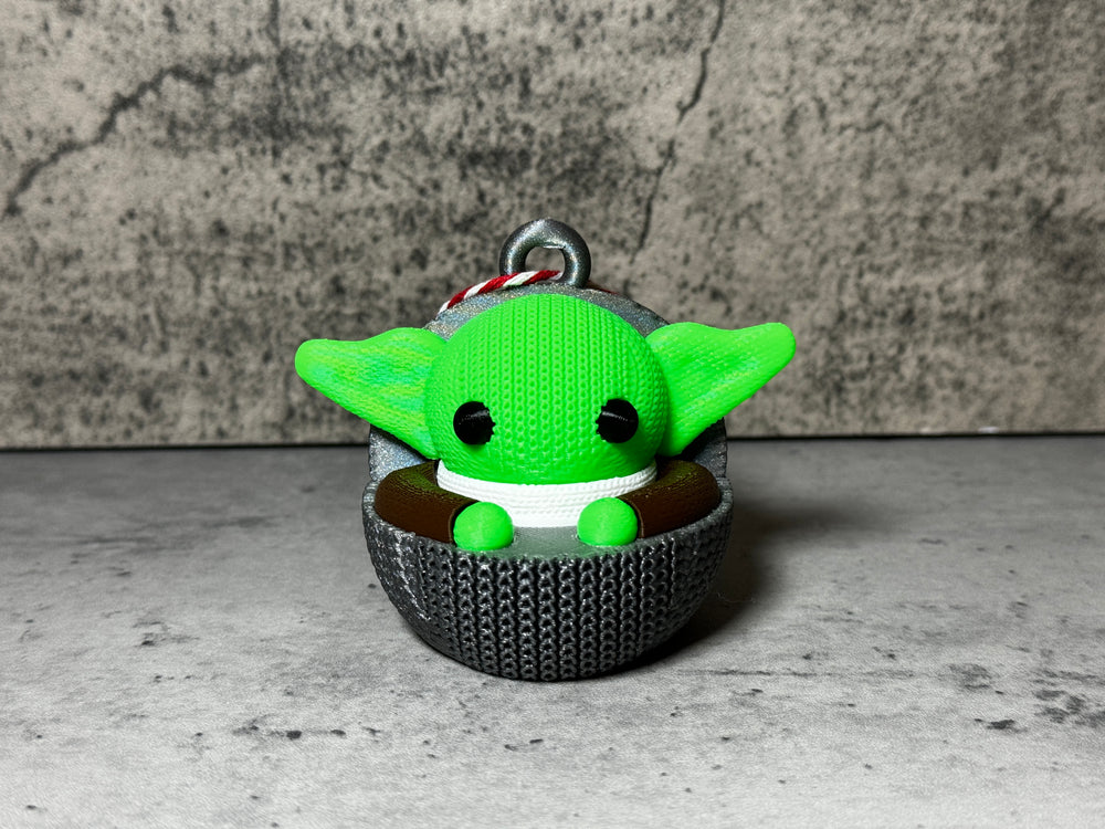 
                  
                    a green stuffed animal sitting in a cup
                  
                