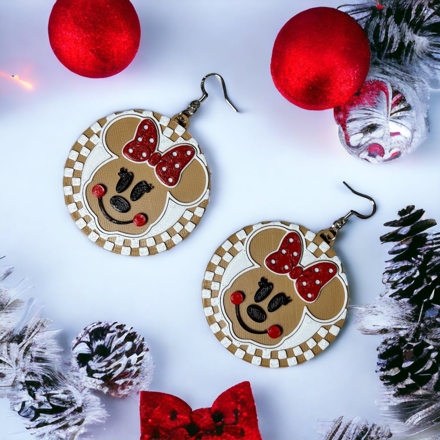 
                  
                    a pair of mickey mouse earrings with a red bow
                  
                