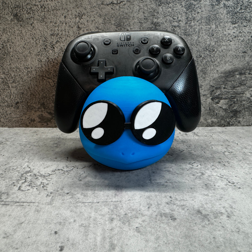 
                  
                    a close up of a controller and a toy
                  
                