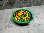 a green and yellow plate with a flower on it