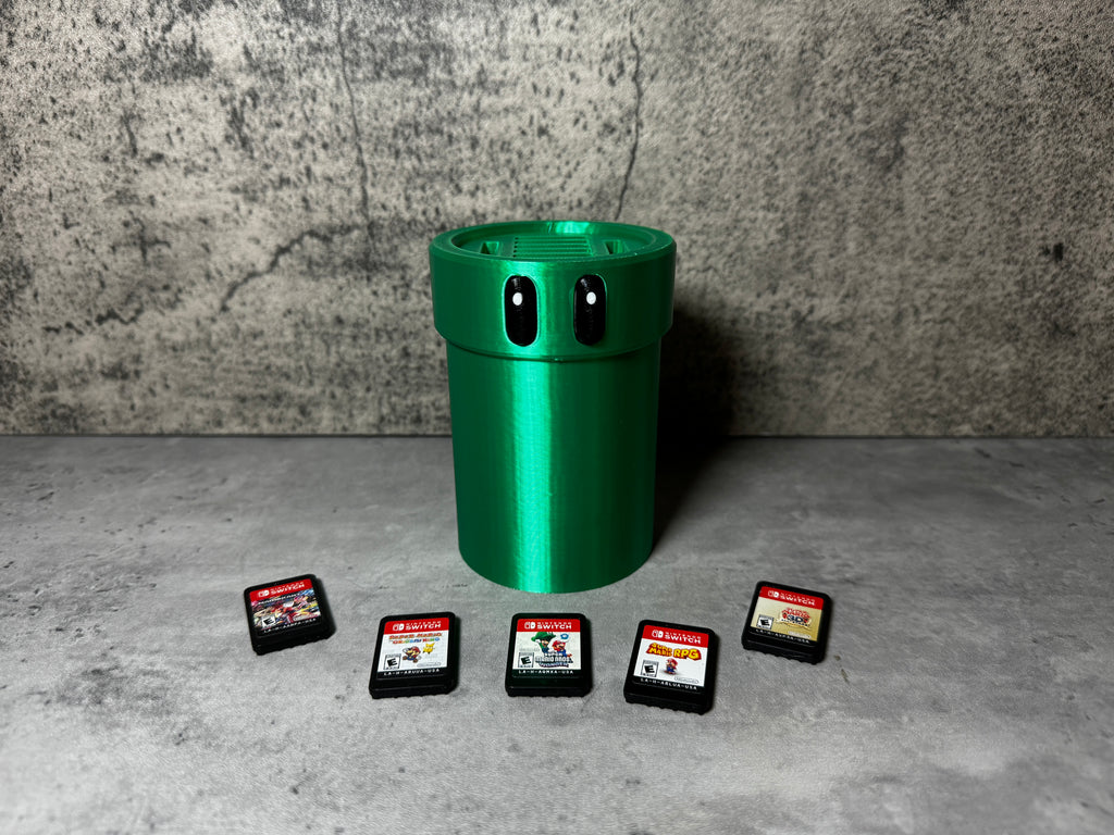 a green trash can sitting next to four game cards