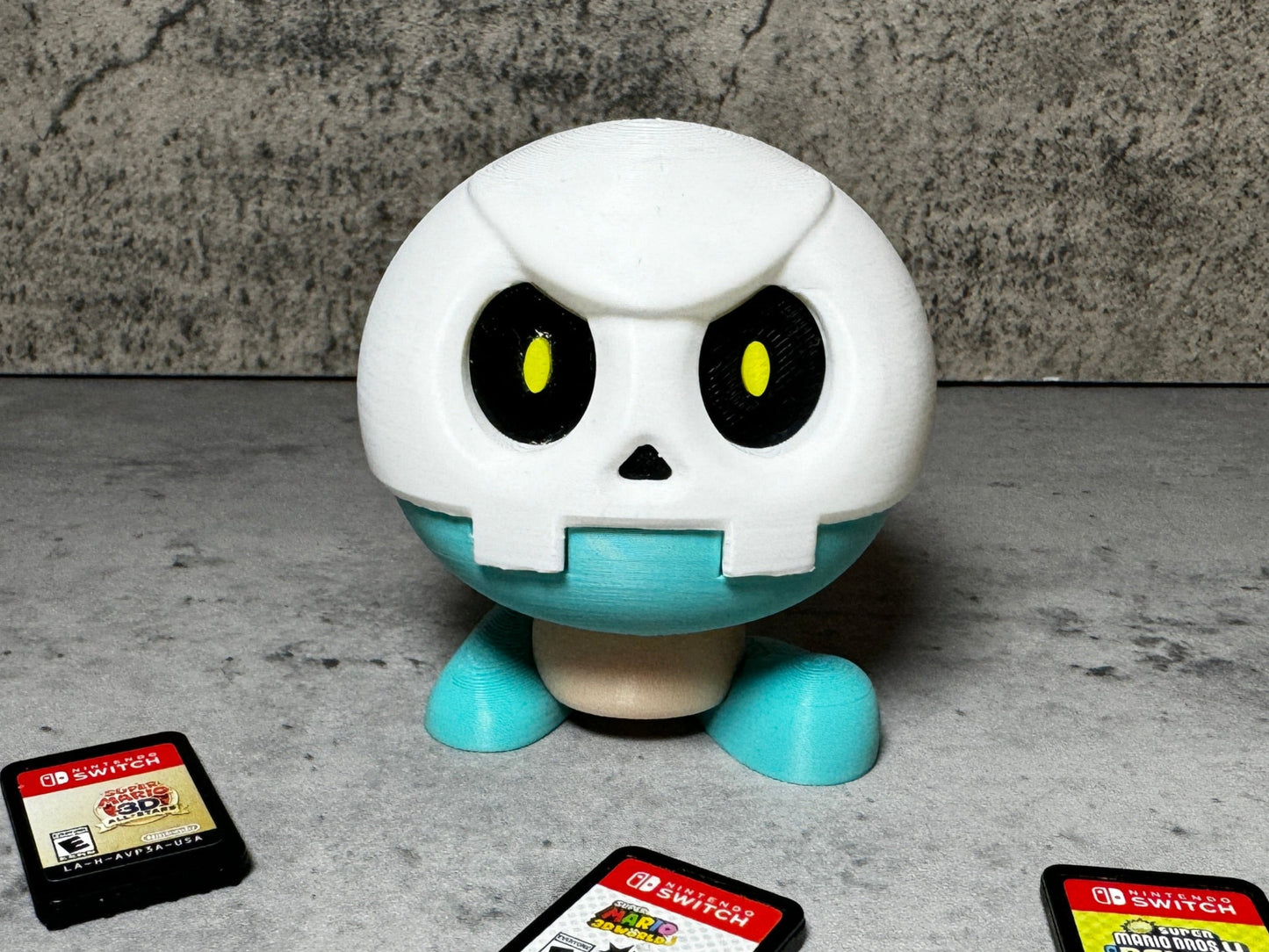 a toy with a skull on it surrounded by gameboy games