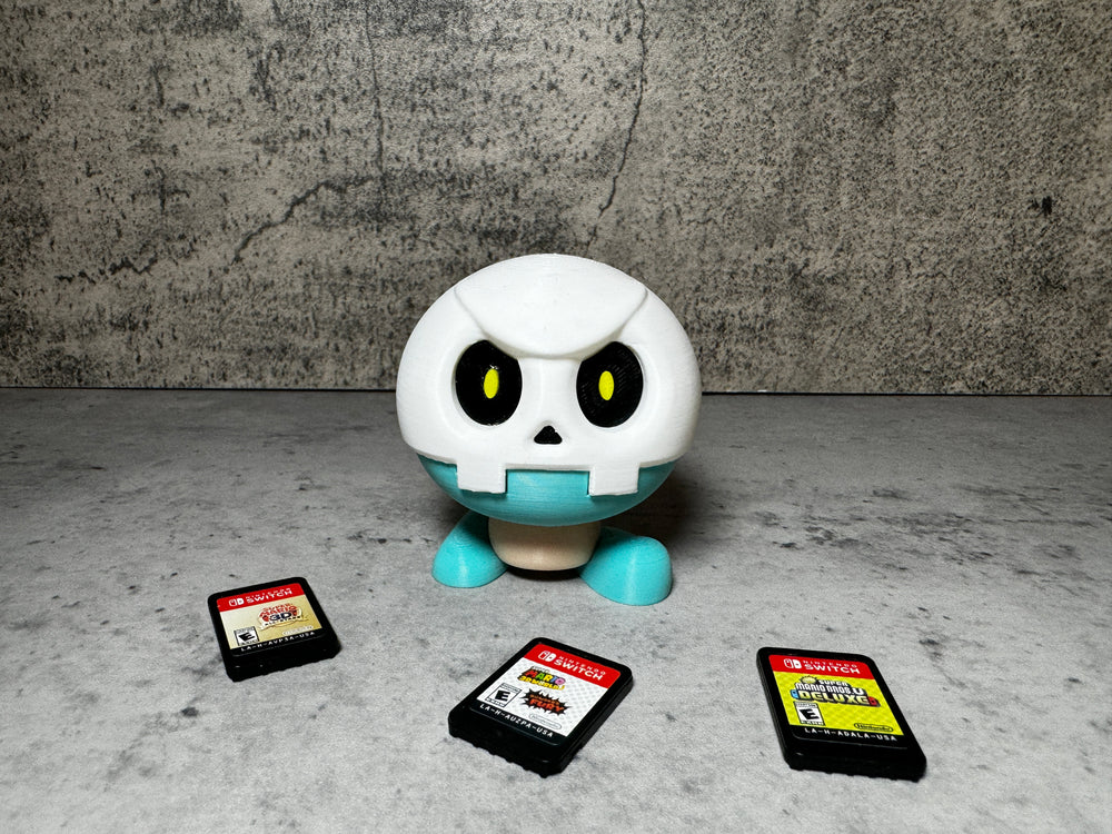 a toy with a skull on it surrounded by gameboy games