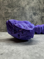 a purple shoe hanging on the side of a wall