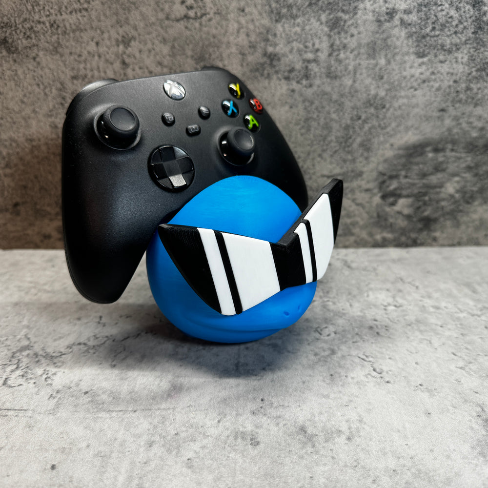 
                  
                    a close up of a controller and a ball
                  
                