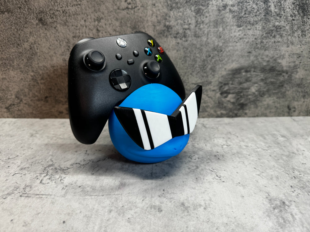 
                  
                    a close up of a controller and a ball
                  
                