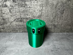 a green cup sitting on top of a cement floor