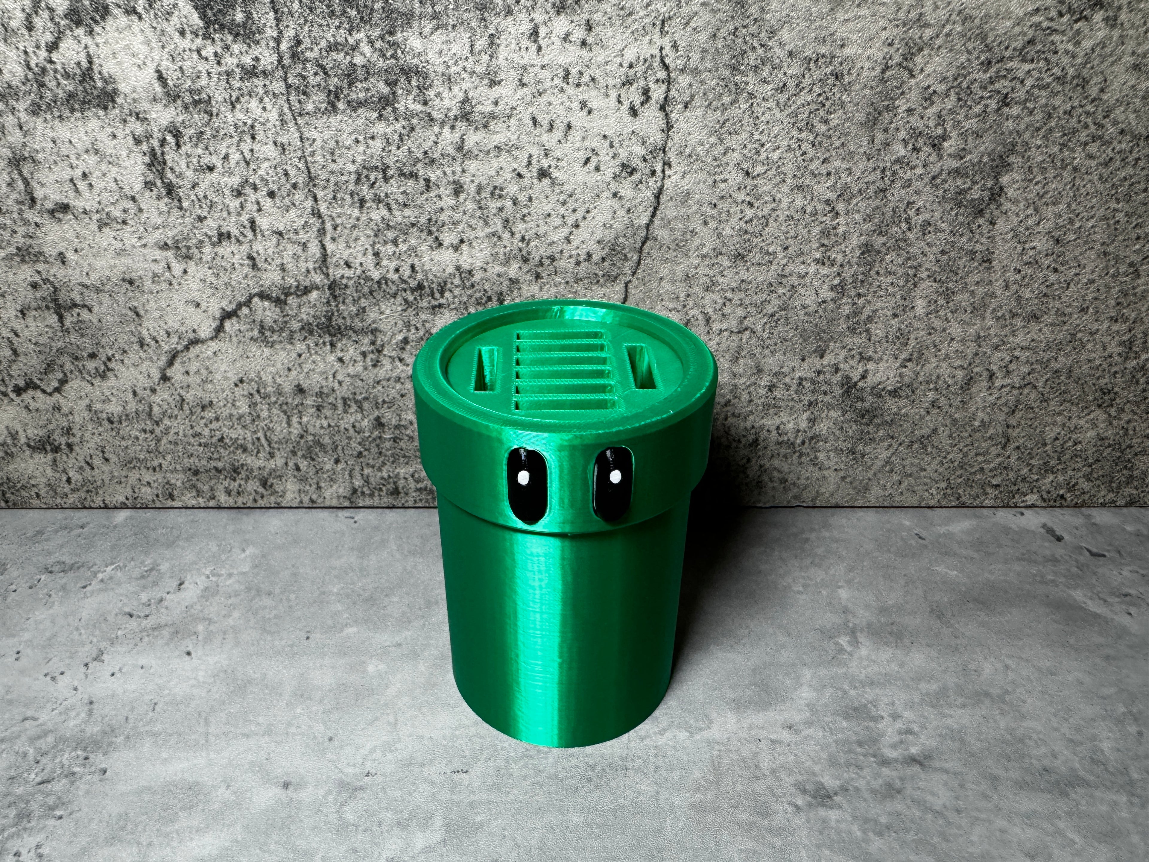 a green cup sitting on top of a cement floor