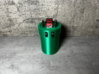 a green trash can sitting on top of a cement floor