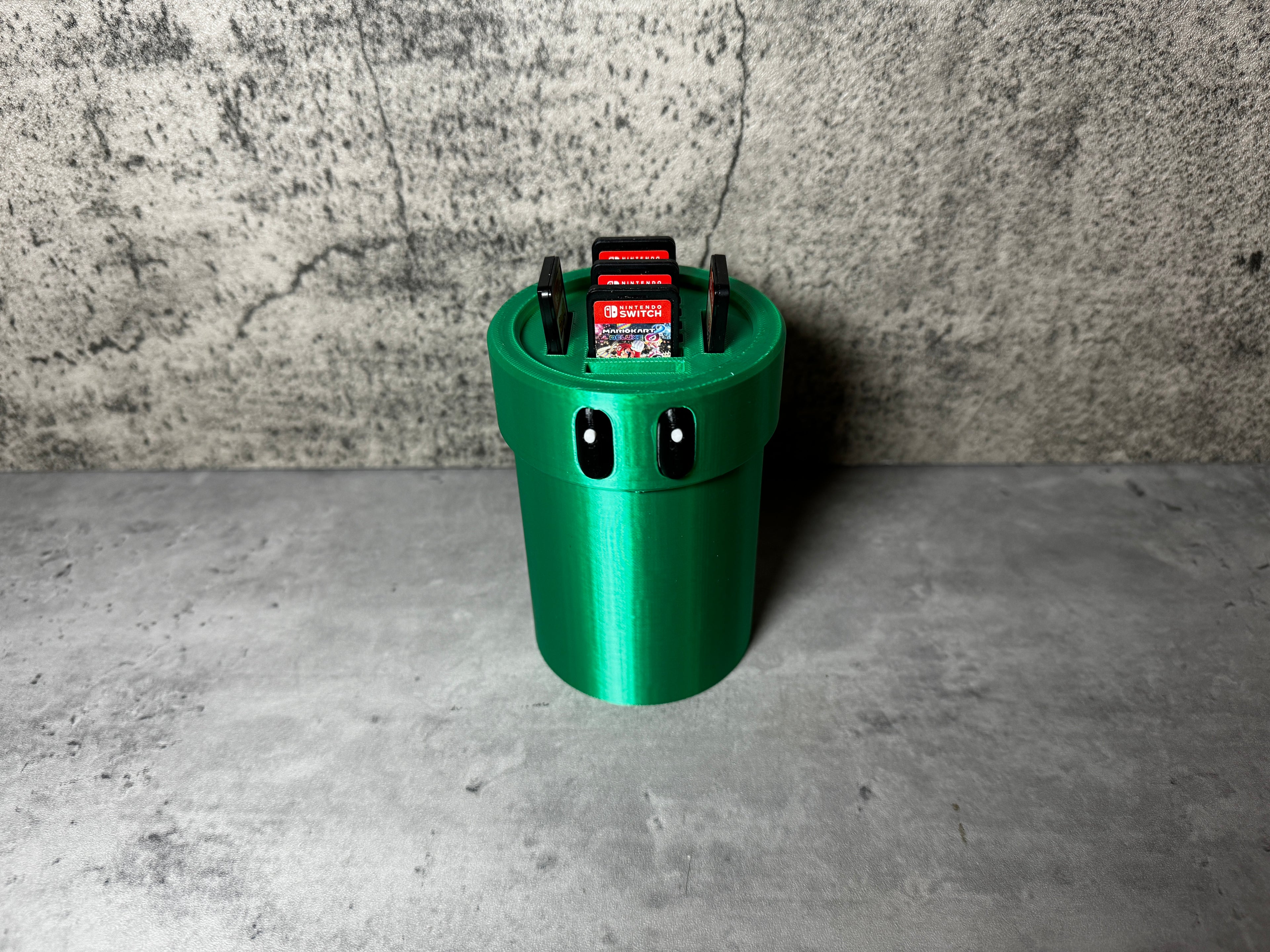 a green trash can sitting on top of a cement floor