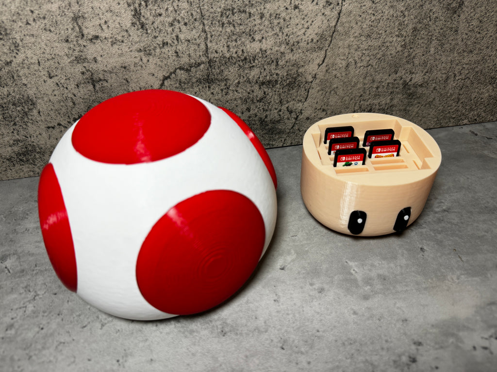 a red and white ball sitting next to a white and black object