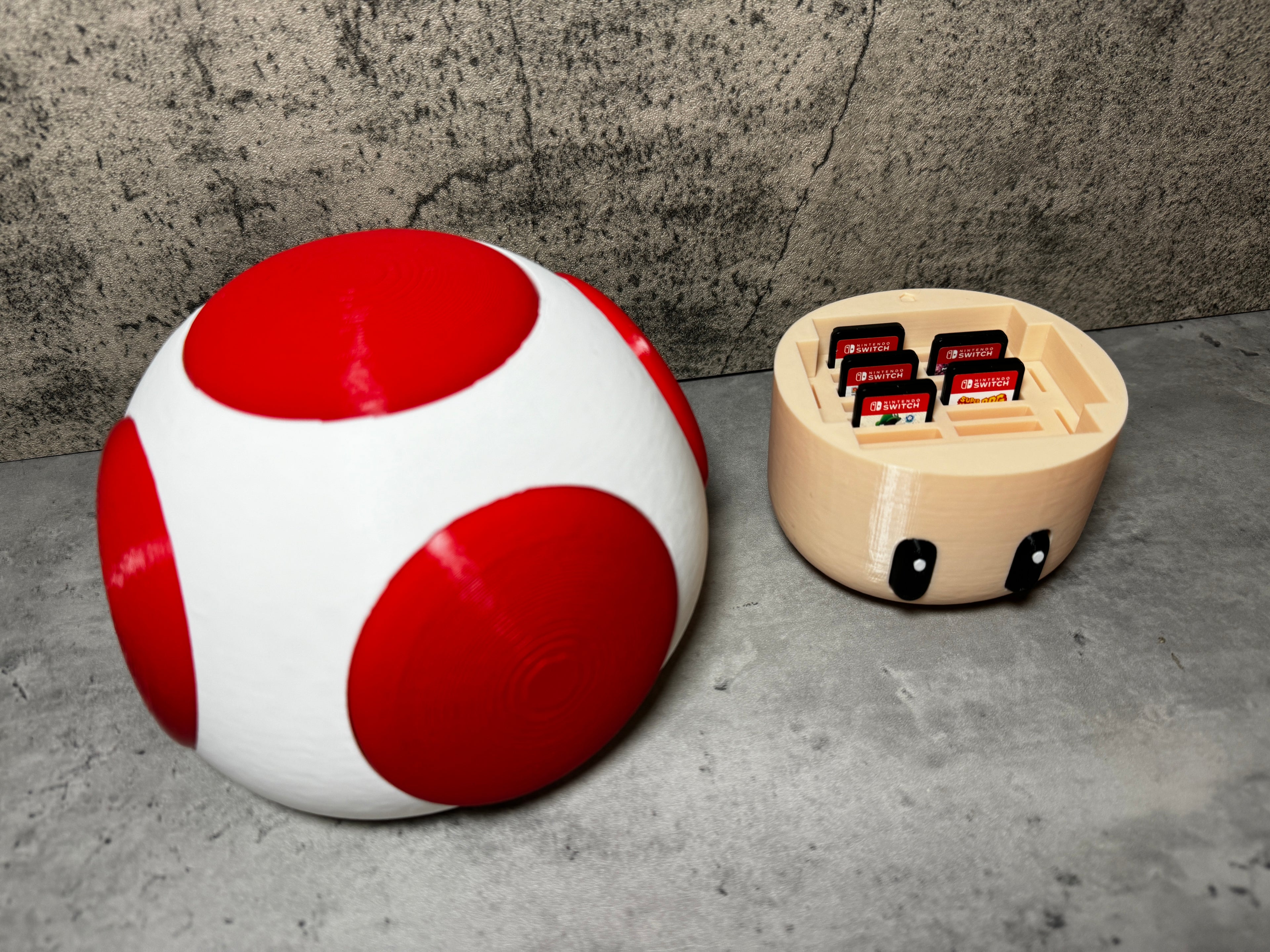 a red and white ball sitting next to a white and black object