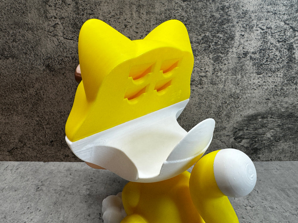 
                  
                    a yellow and white cat toy sitting on the ground
                  
                