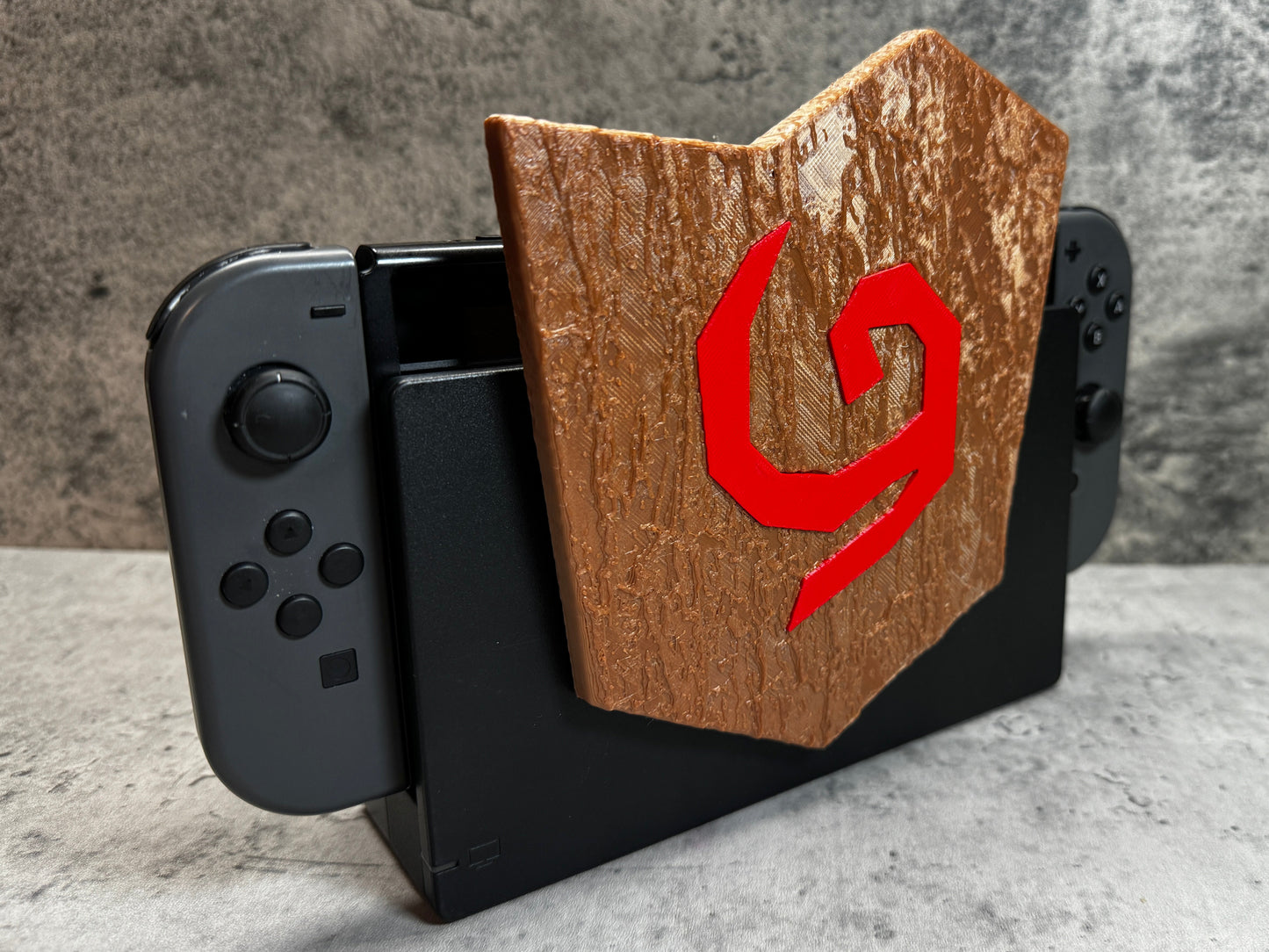 a wooden phone holder with a red g on it