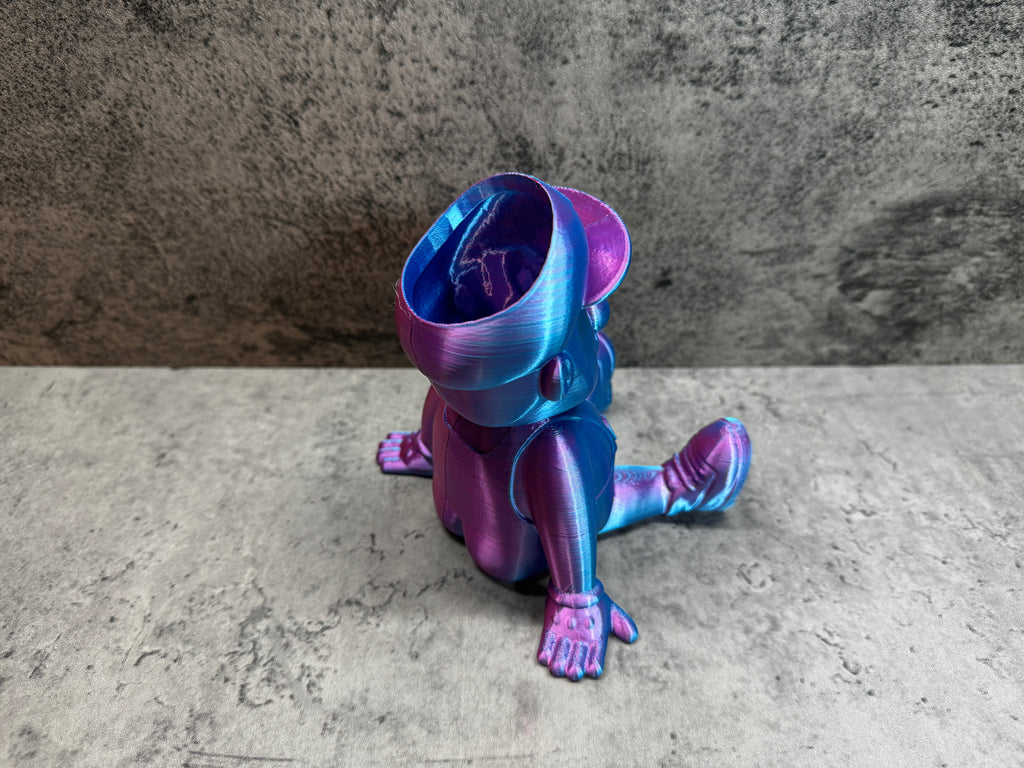 a purple and blue toy sitting on top of a cement floor