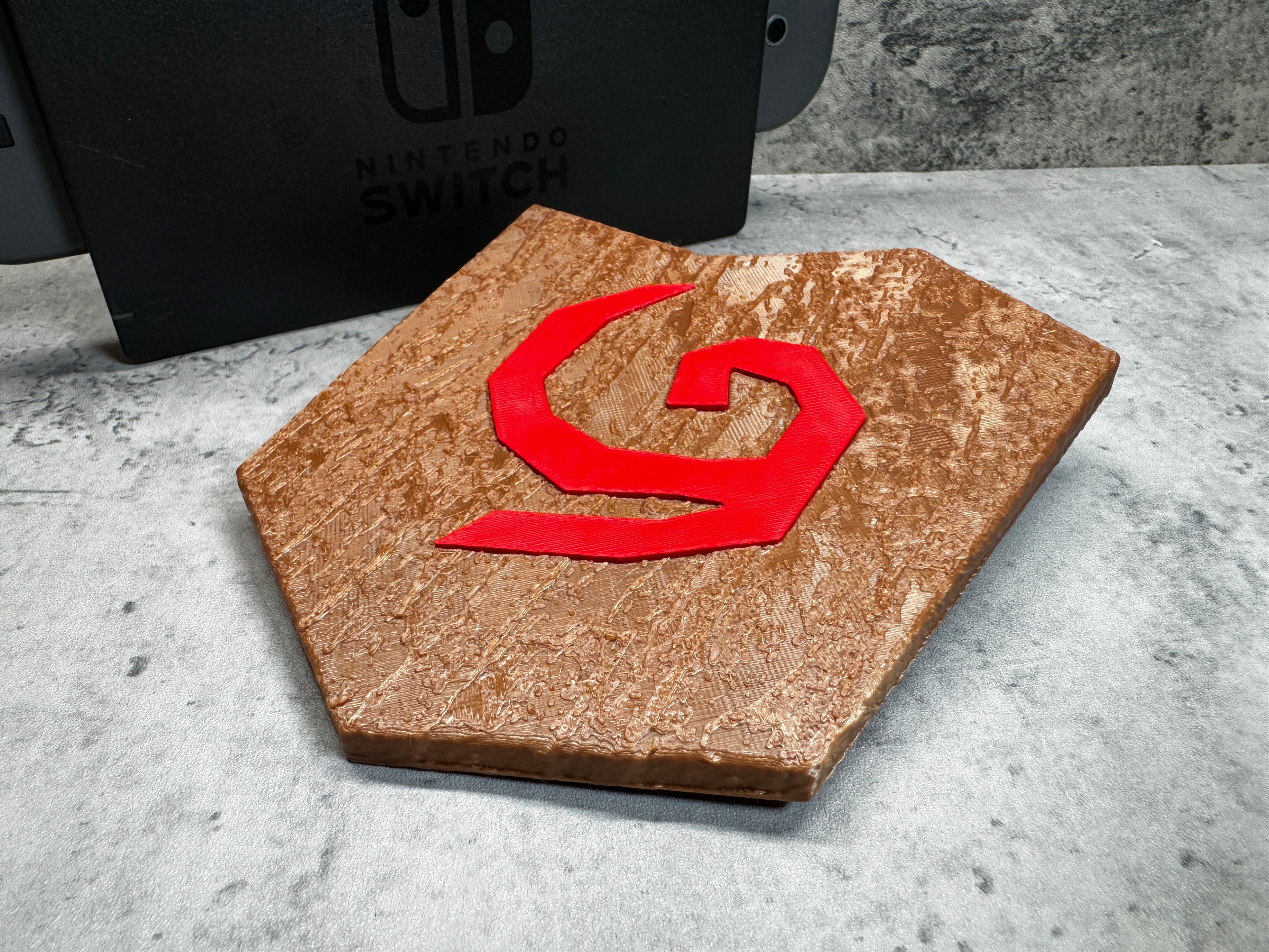 a wooden object with a red letter on it