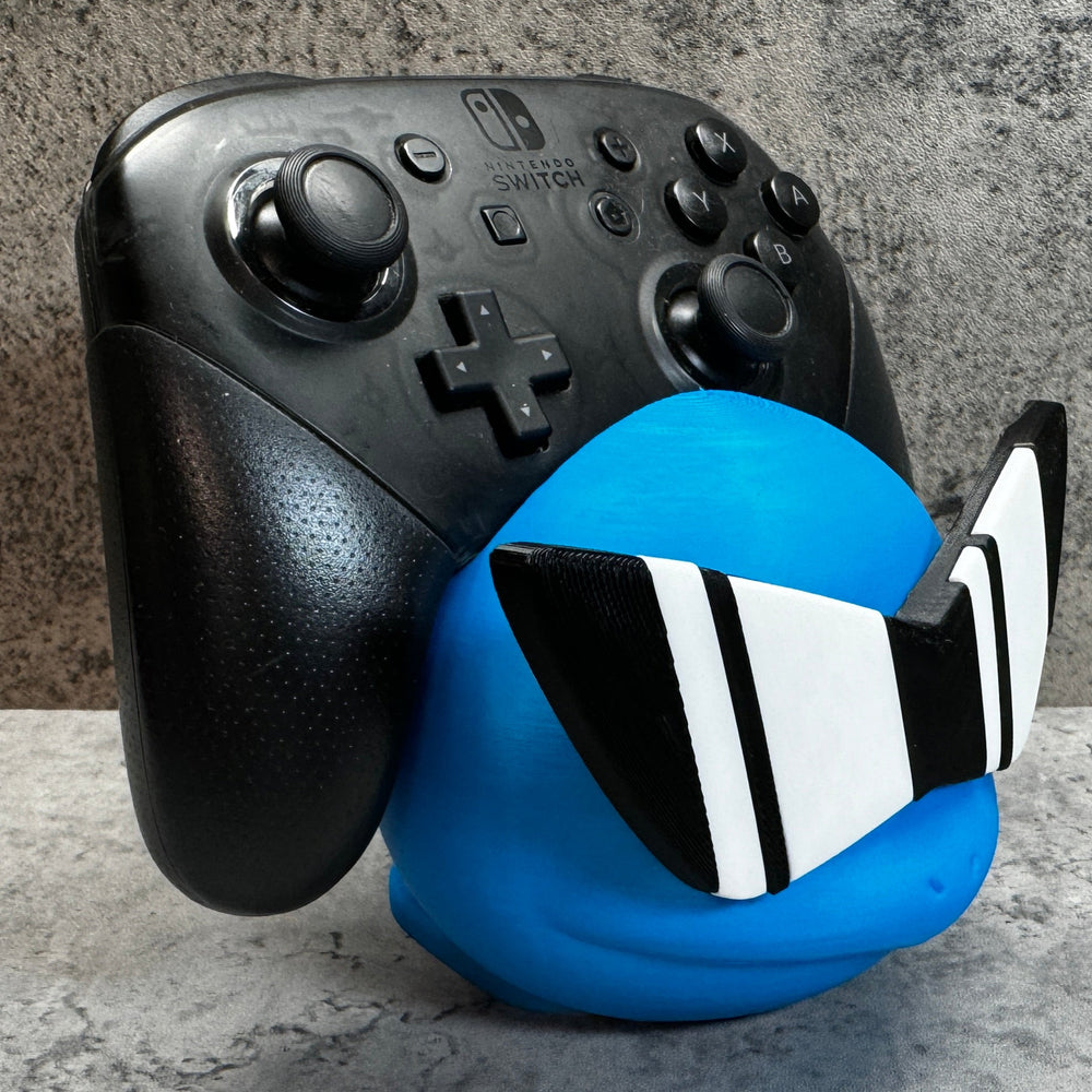 
                  
                    a close up of a controller and a ball
                  
                