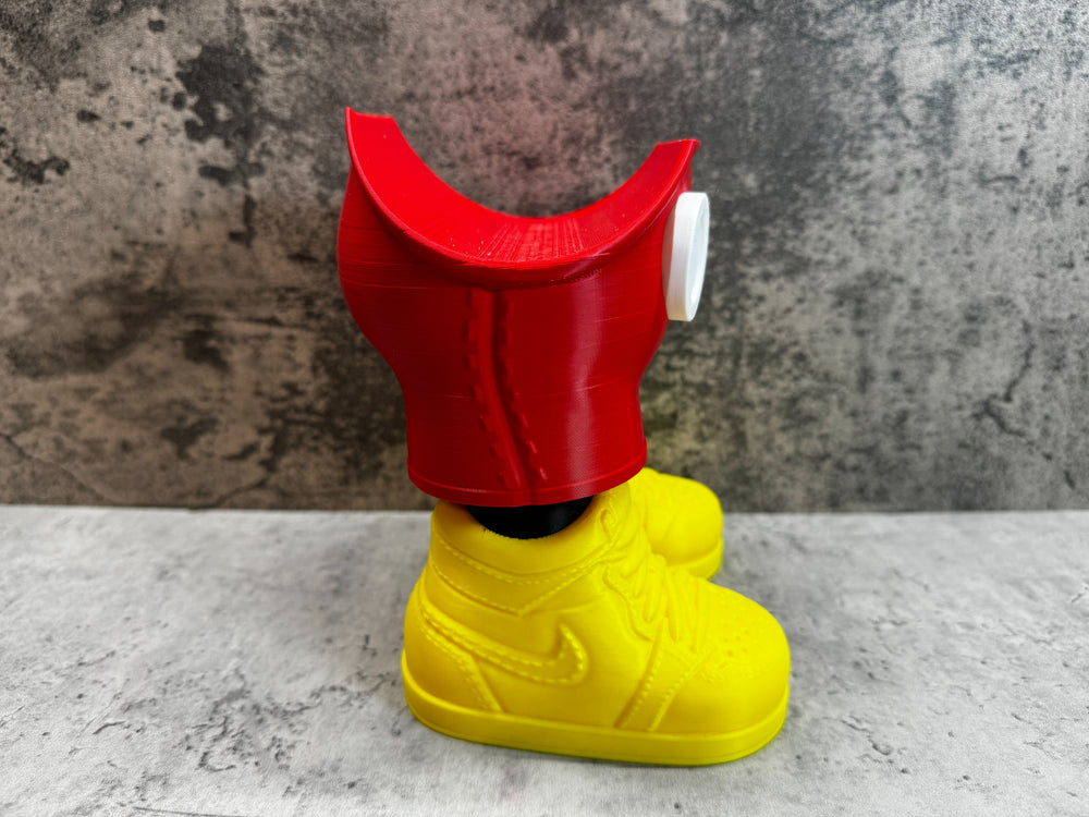 
                  
                    a yellow shoe with a red hat on top of it
                  
                