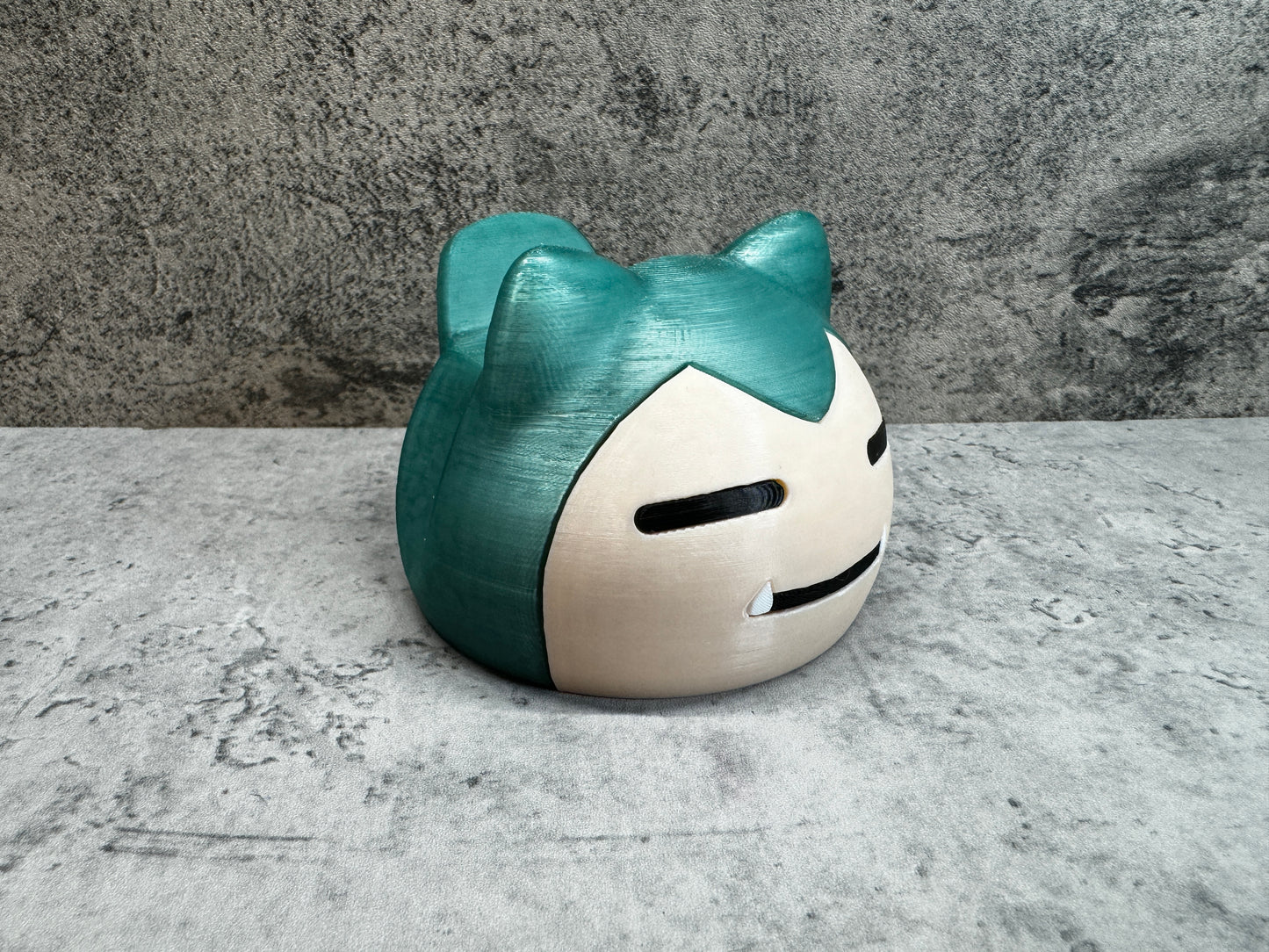 
                  
                    a white and green cat shaped vase sitting on top of a table
                  
                