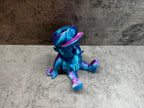 a blue and purple toy sitting on the ground