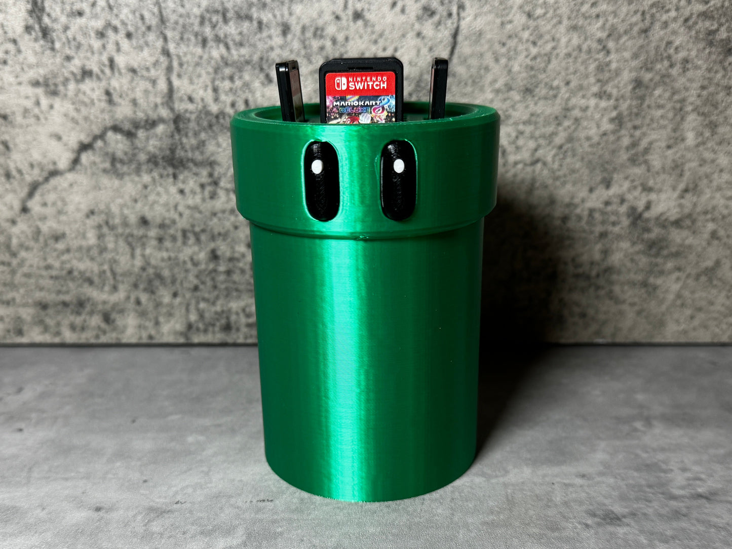 a green trash can sitting on top of a cement floor