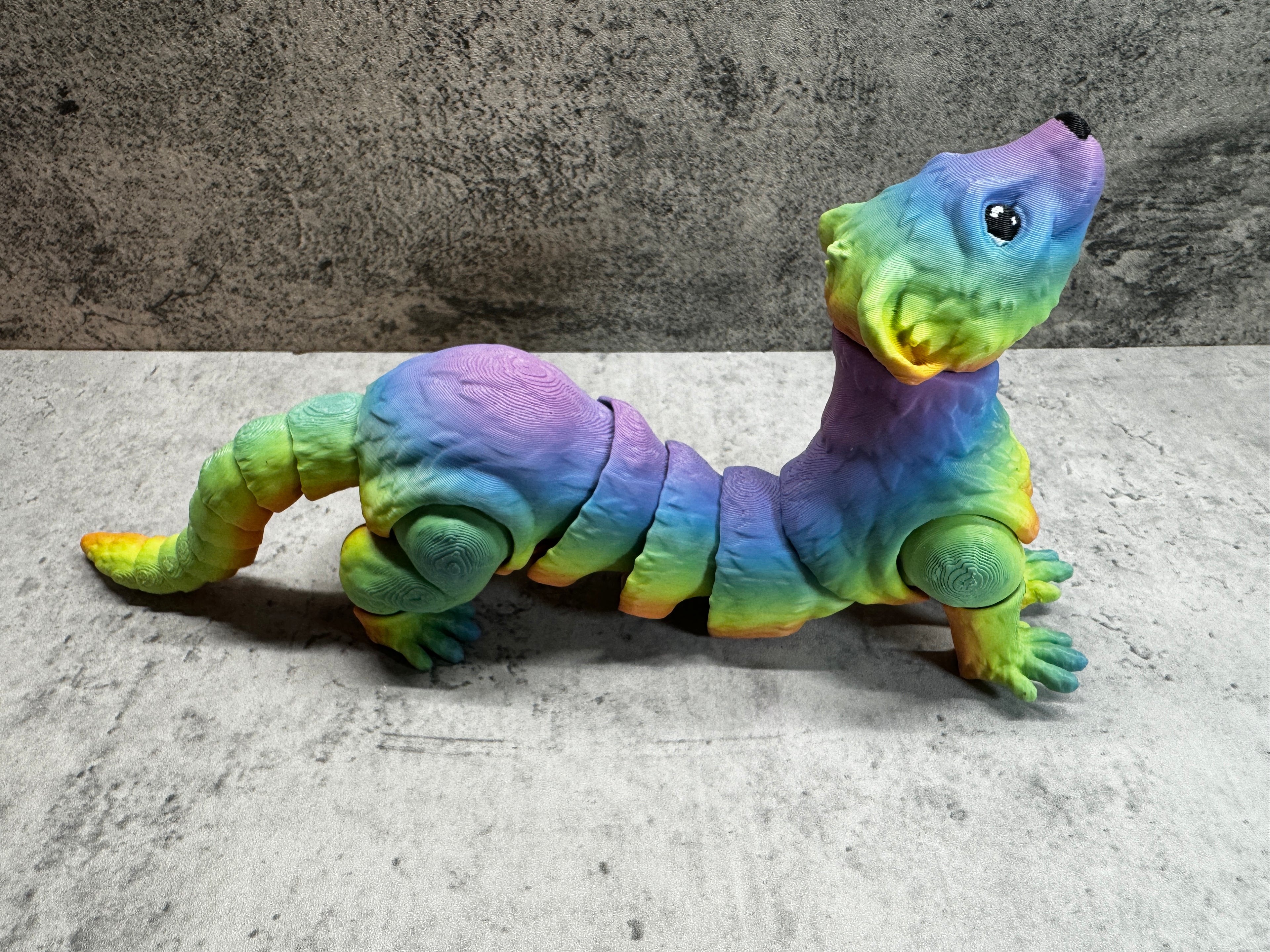 a toy lizard sitting on its side on the ground