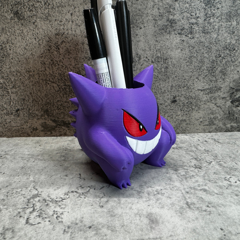 
                  
                    a purple toy with red eyes and a toothbrush holder
                  
                