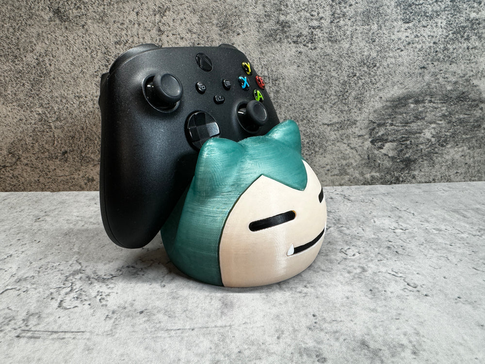 
                  
                    a close up of a controller and a figurine
                  
                