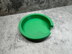 a green bowl sitting on top of a cement floor