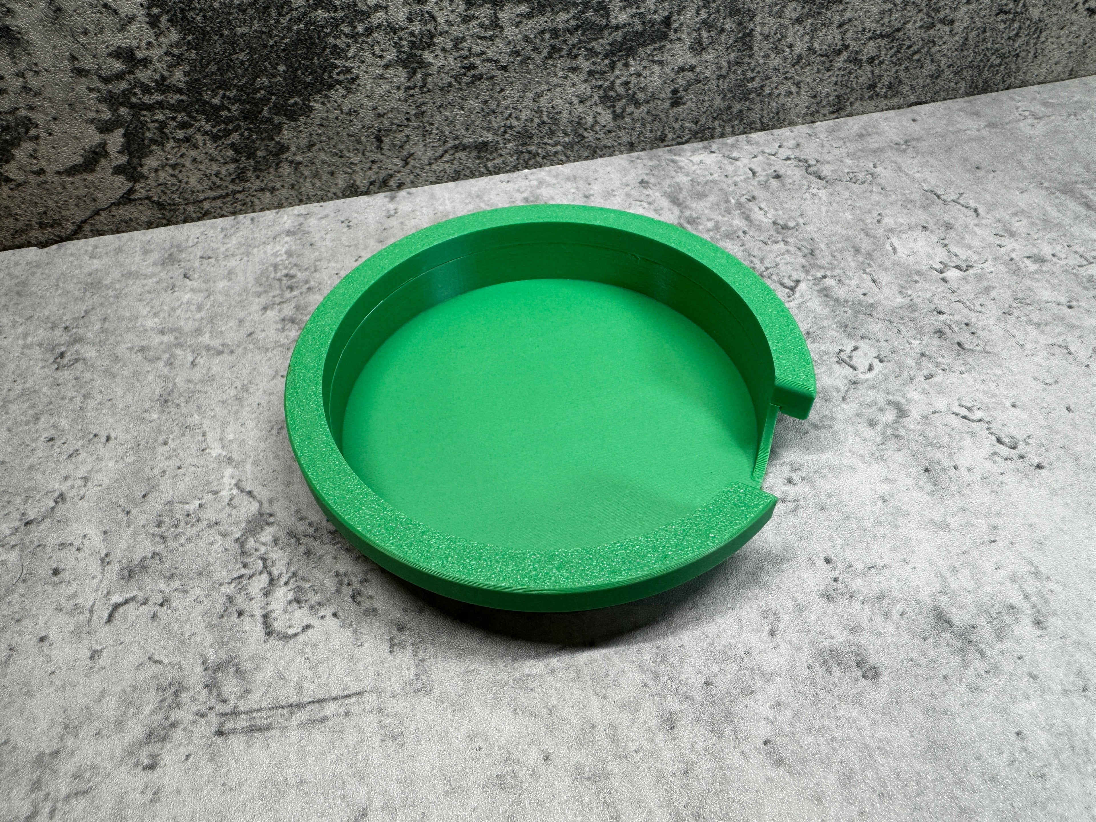 a green bowl sitting on top of a cement floor