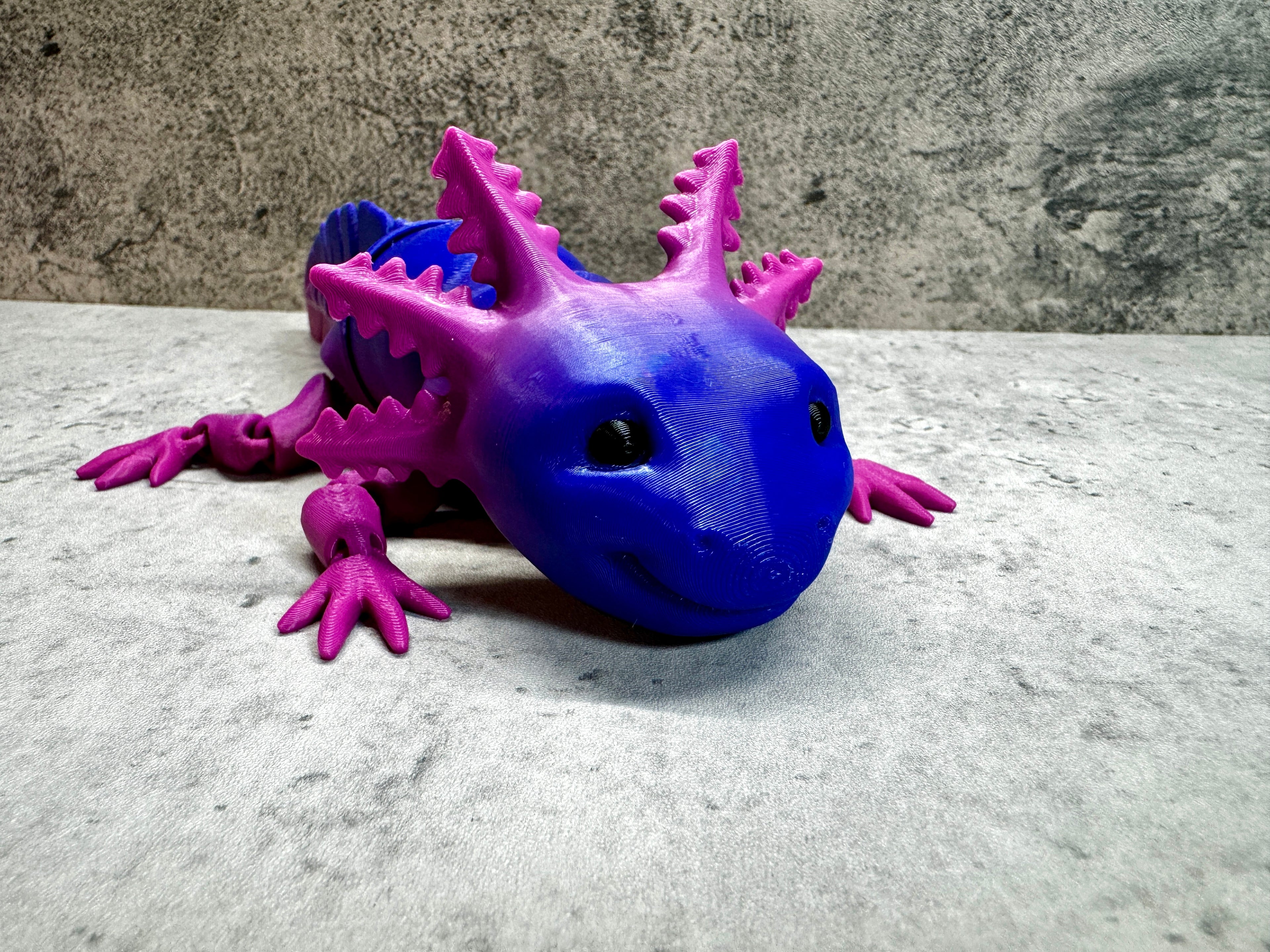 a purple and blue toy lizard sitting on a table