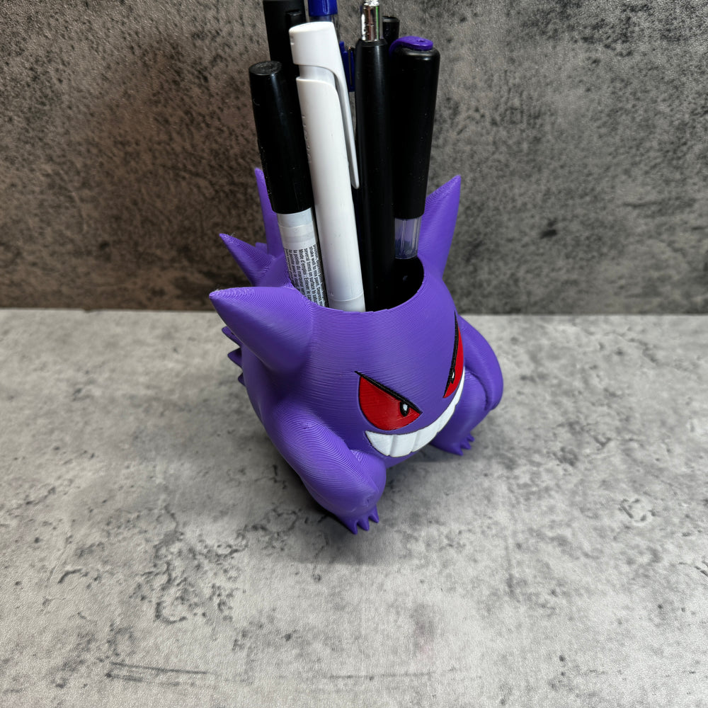 
                  
                    a cup that has some pens in it
                  
                