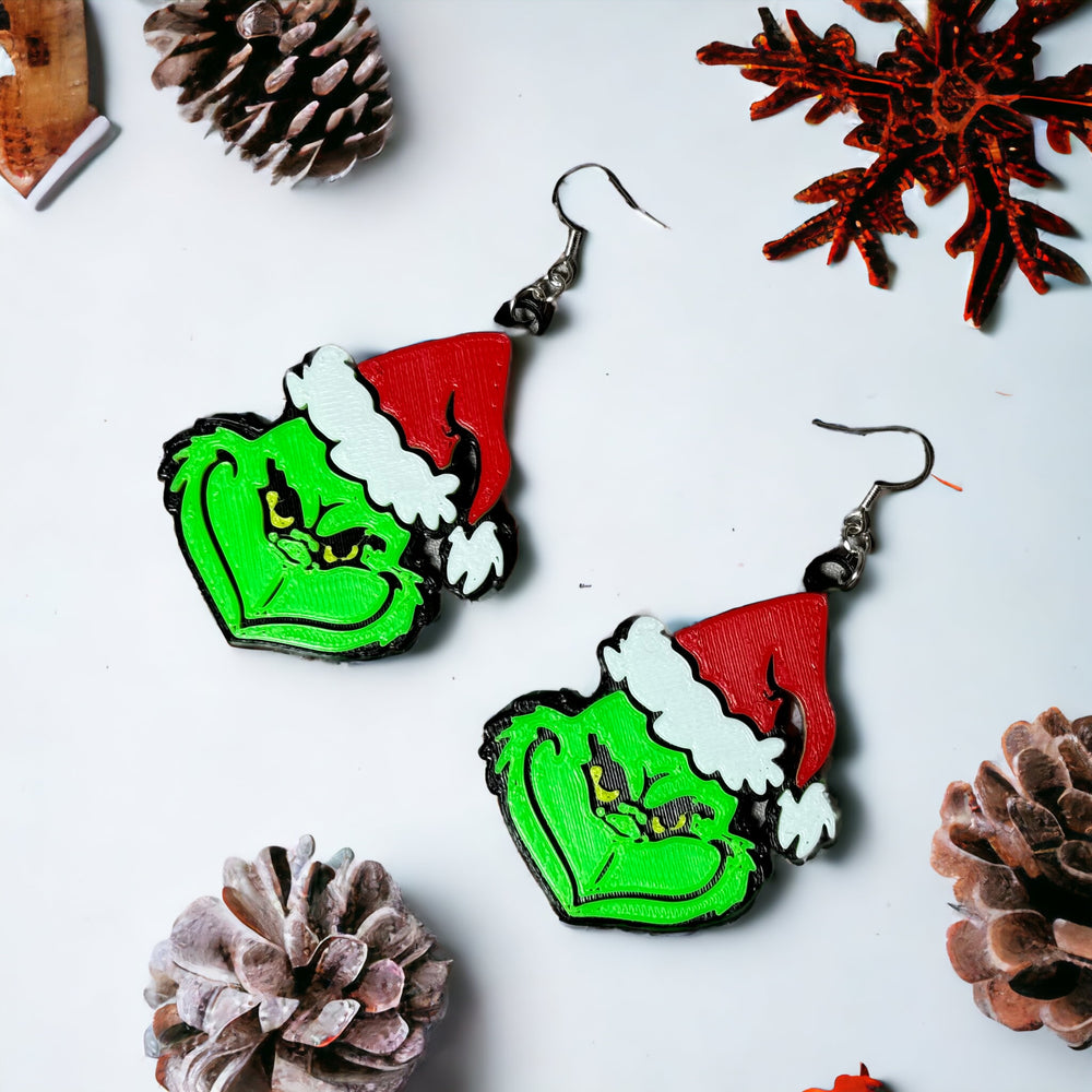 a pair of earrings with the grin face painted on them