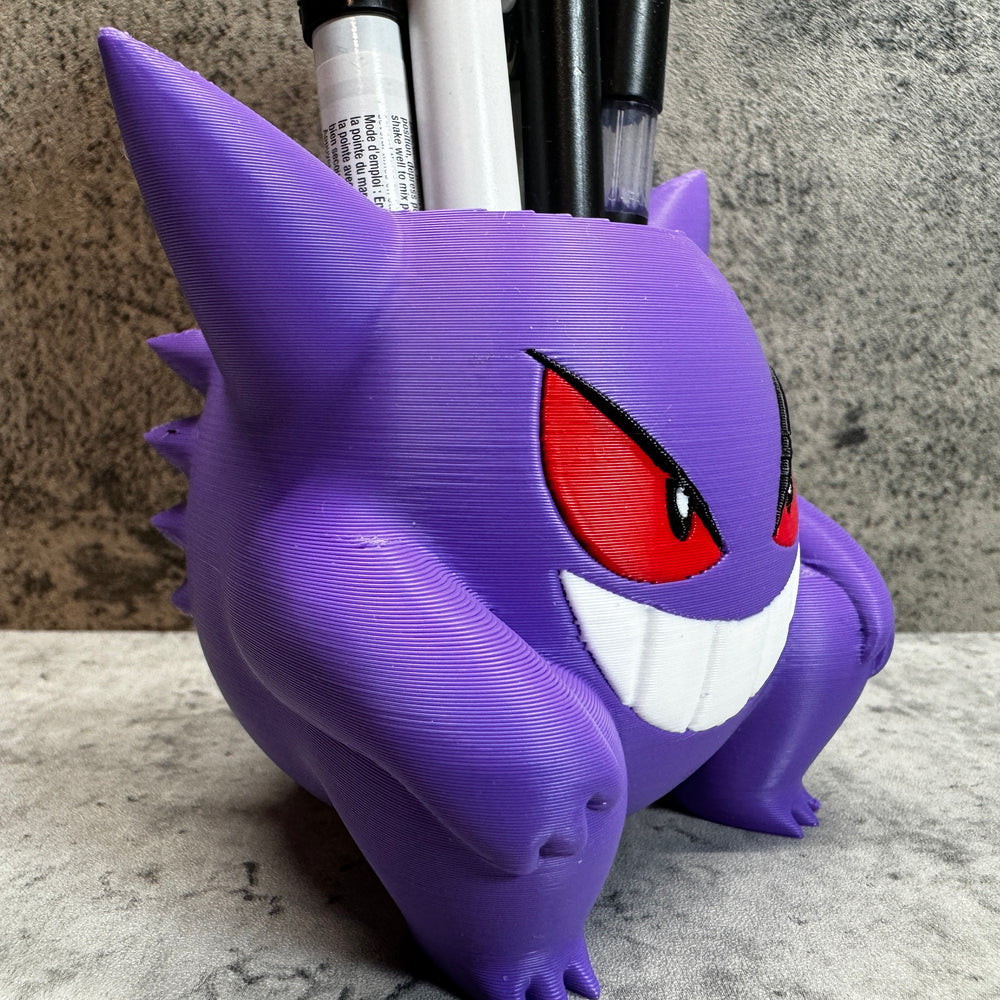 a purple toy with red eyes and a toothbrush holder
