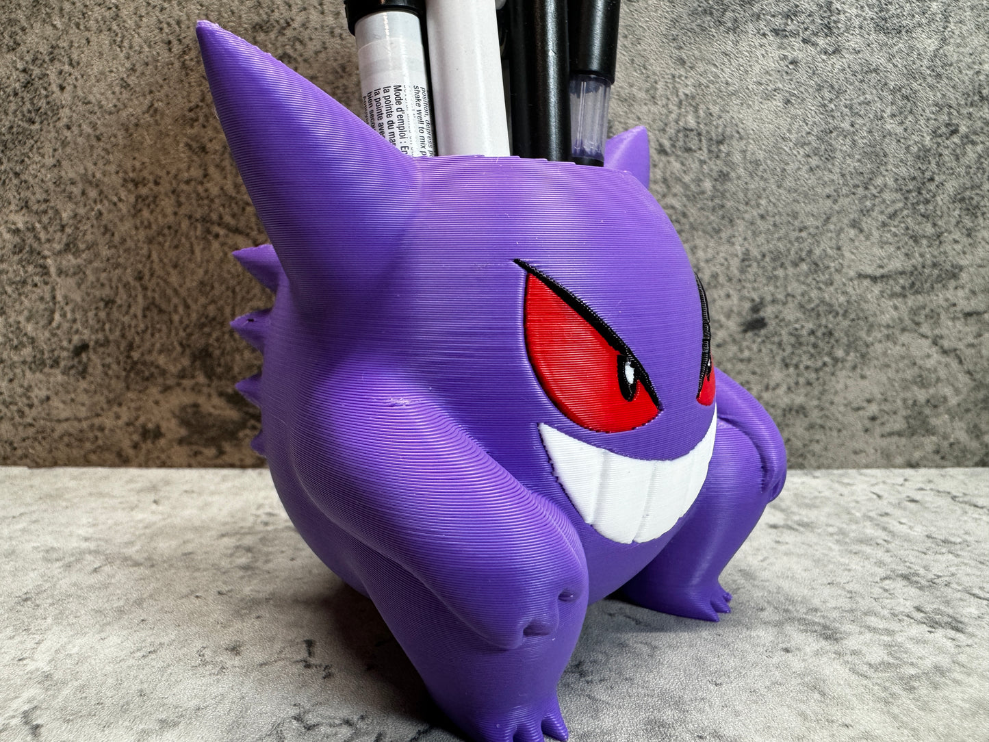 a purple toy with red eyes and a toothbrush holder